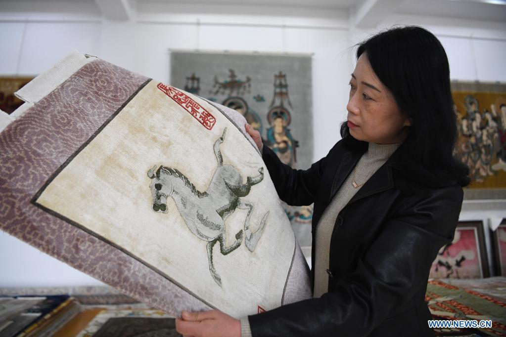 Craftwoman makes efforts to carry on tradition of making silk carpets