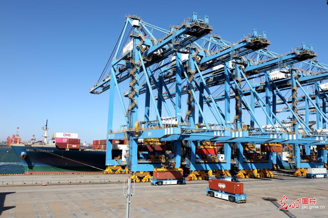 Trucks load cargos at smart terminal of Qingdao Port