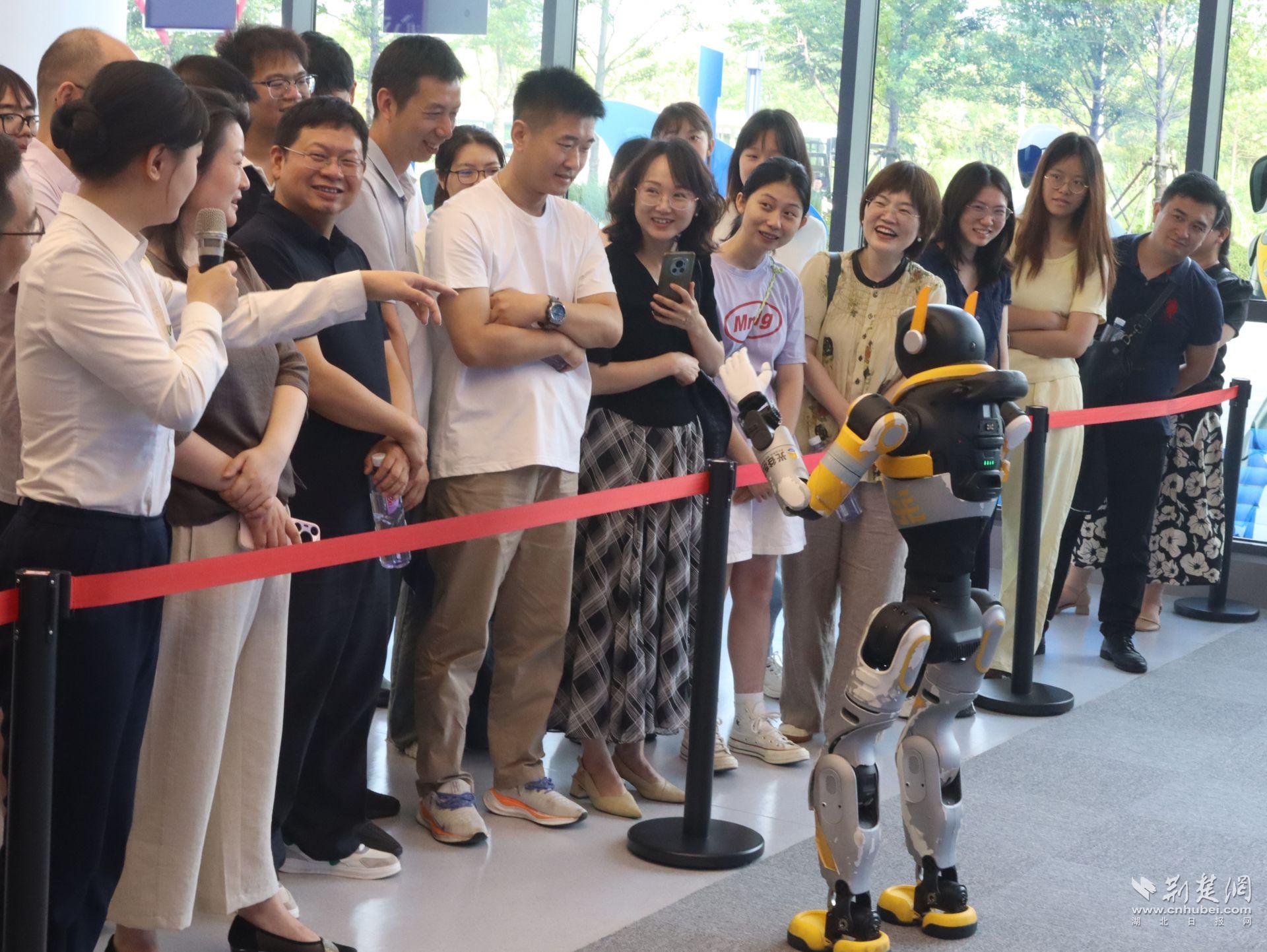 学懂用AI!中南民大开展“AI技能+数智素养提升月”活动 AI企业参观现场,师生与机器人互动。侯佳音 摄.jpg.jpg