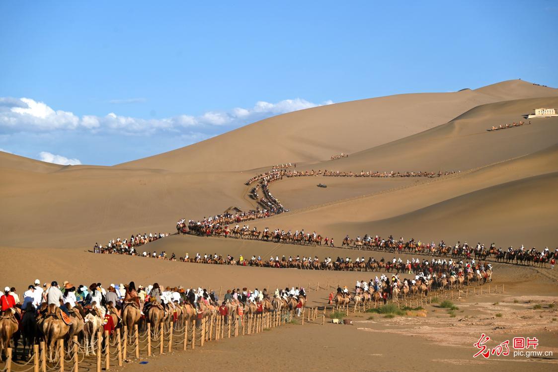 Tourists flock to Mingsha Mountain and Crescent Spring in NW China's Gansu