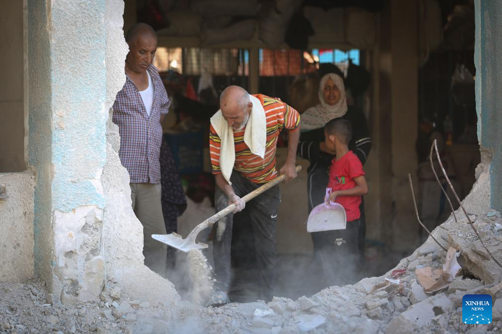 People conduct clean up work at UN-affiliated school after Israeli attack in Gaza