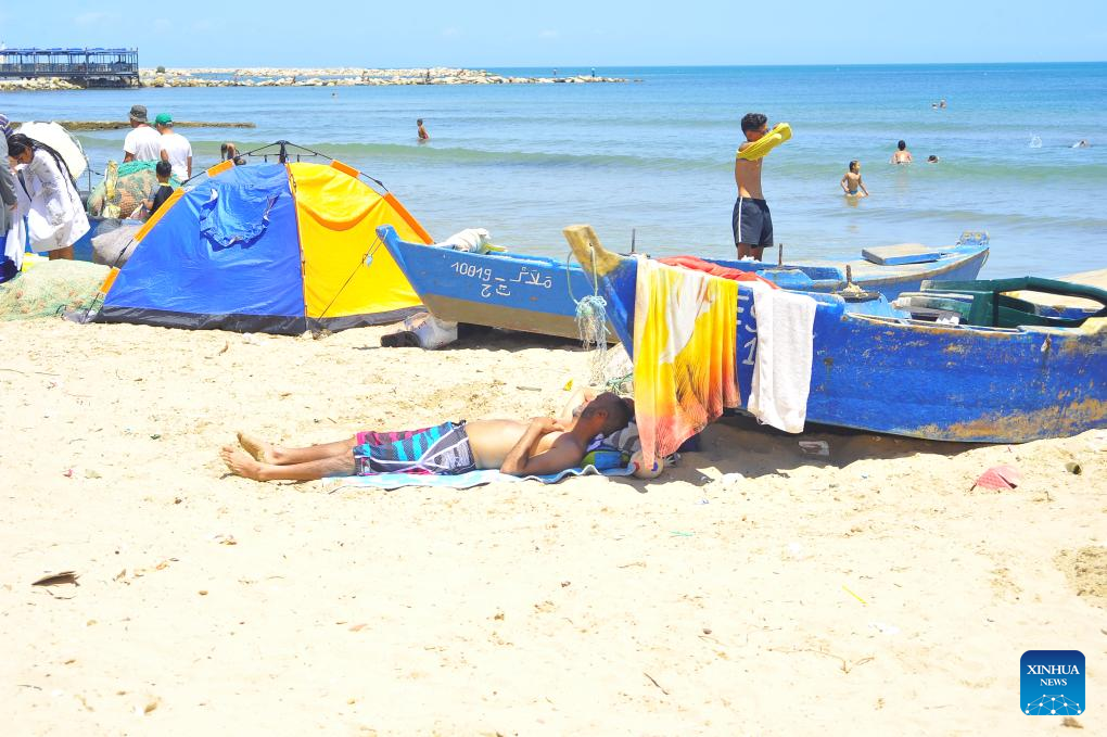 People cool off by seaside during heat wave in Tunis