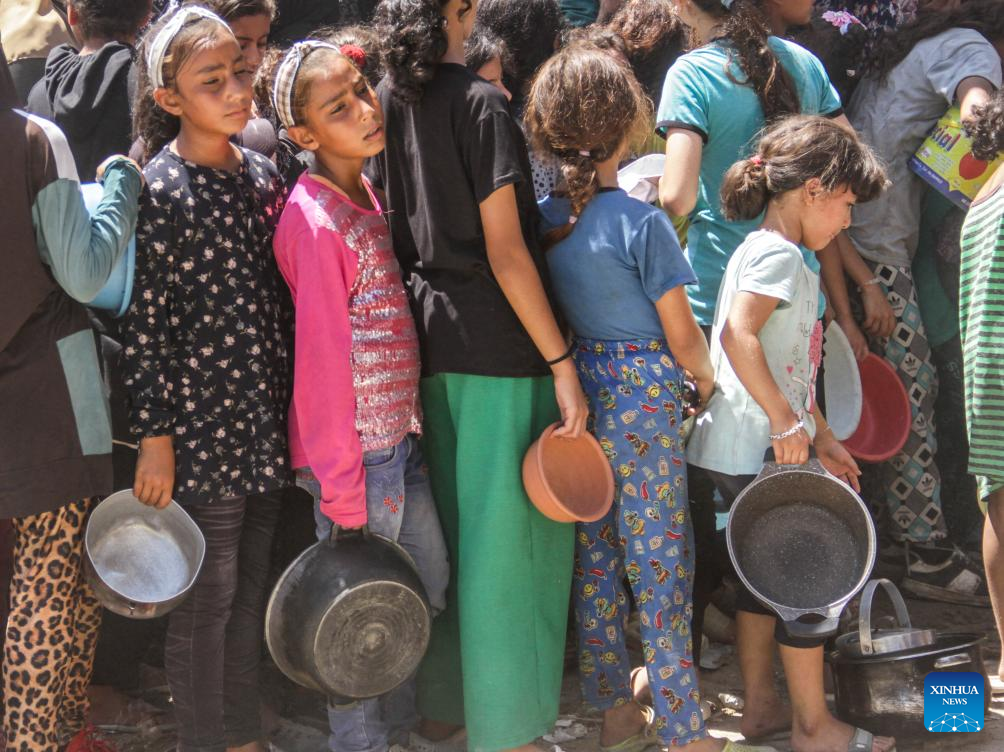 People gather to receive food relief in Jabalia refugee camp in Gaza Strip