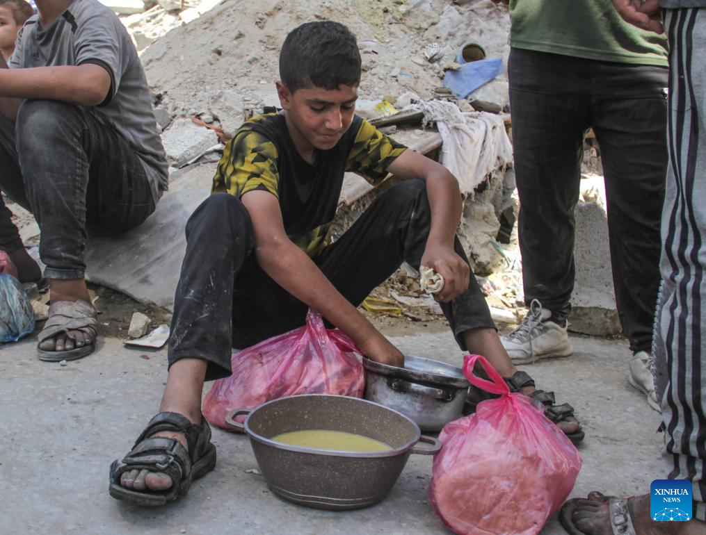 People gather to receive food relief in Jabalia refugee camp in Gaza Strip