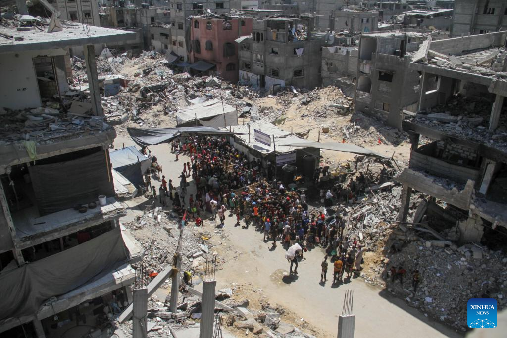 People gather to receive food relief in Jabalia refugee camp in Gaza Strip