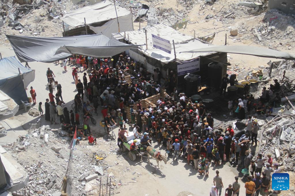 People gather to receive food relief in Jabalia refugee camp in Gaza Strip