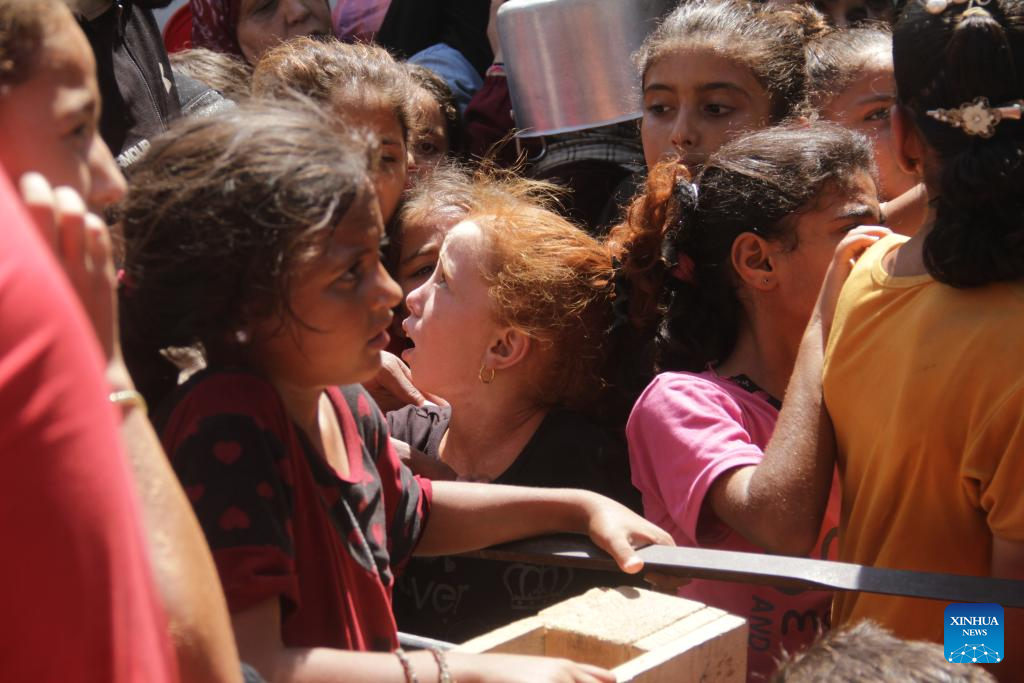 People gather to receive food relief in Jabalia refugee camp in Gaza Strip