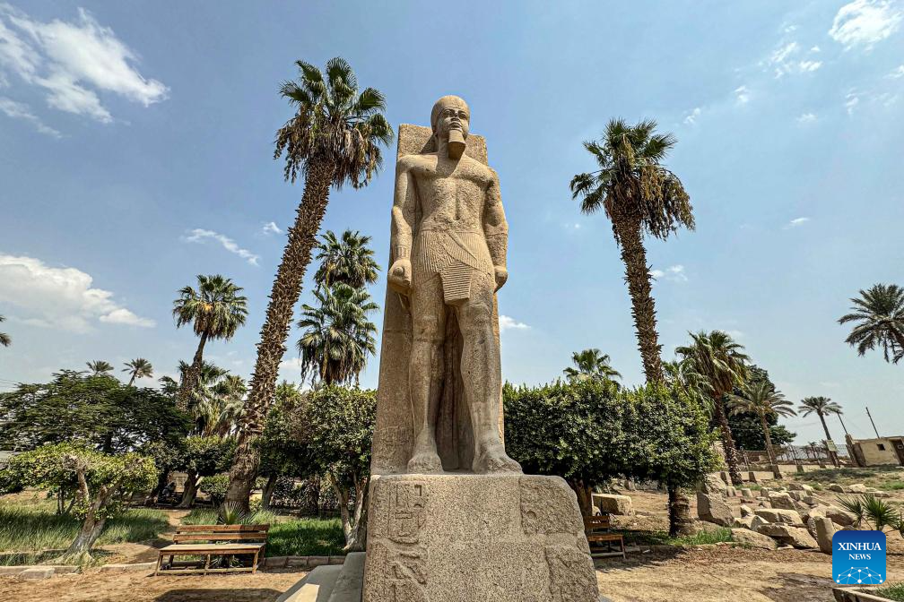 Tourists look at statue of ancient Egyptian king at Mit Rahina Museum