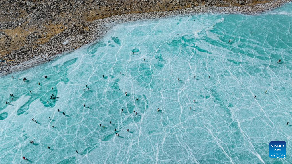 Tourists have fun on icy lake in Lhasa, China's Xizang