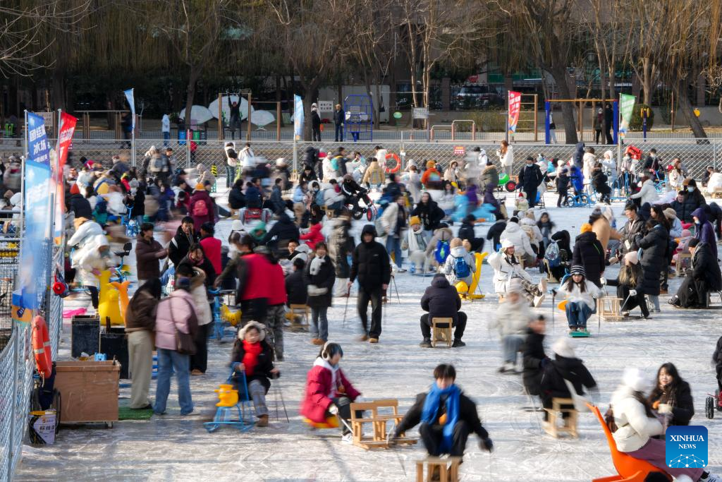 People have fun on ice rink at Tuanjiehu Park in Beijing