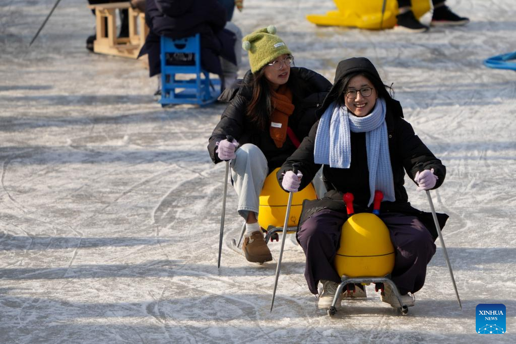 People have fun on ice rink at Tuanjiehu Park in Beijing