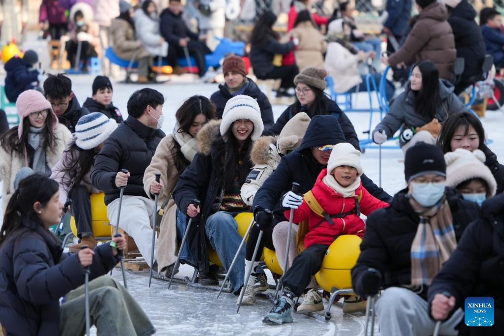 People have fun on ice rink at Tuanjiehu Park in Beijing