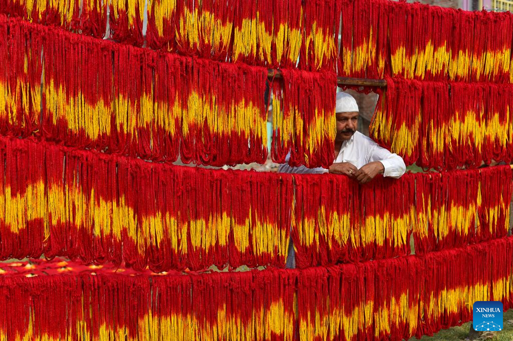 Artisans hang freshly dyed kalawa thread at village in Prayagraj, India