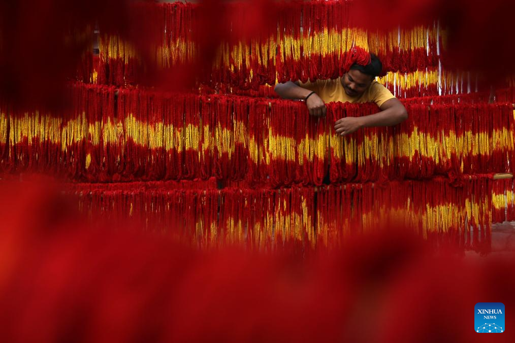 Artisans hang freshly dyed kalawa thread at village in Prayagraj, India