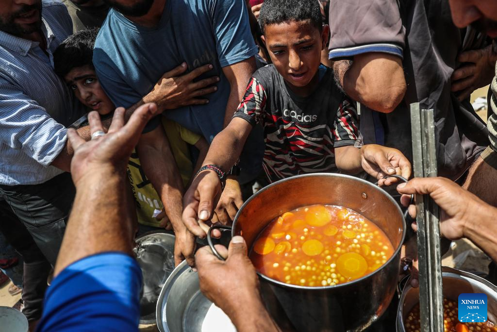 Palestinians receive free food at food distribution center in Gaza City