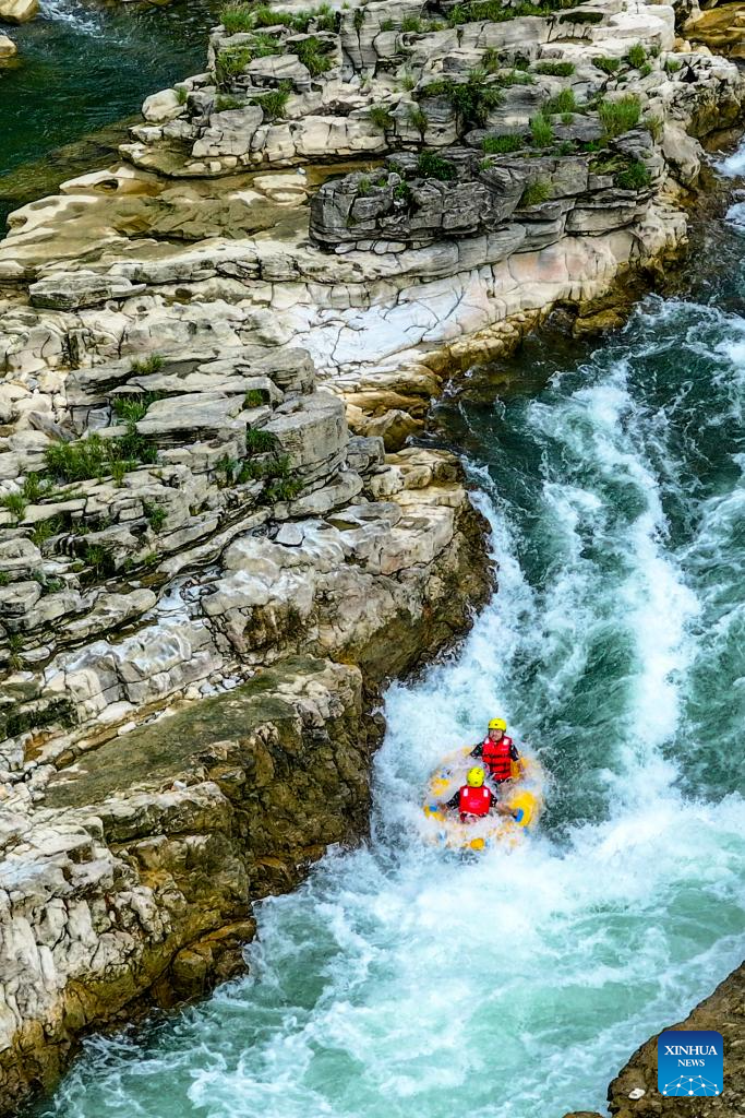 People raft in inflatable boats on Luobei River in Guizhou