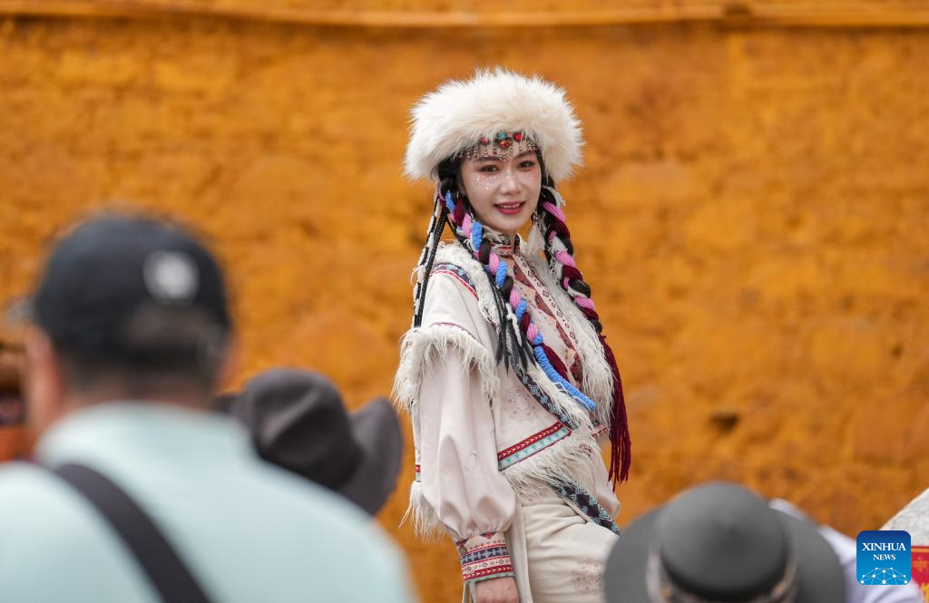 Tourists in Xizang adorn themselves in traditional Tibetan costumes