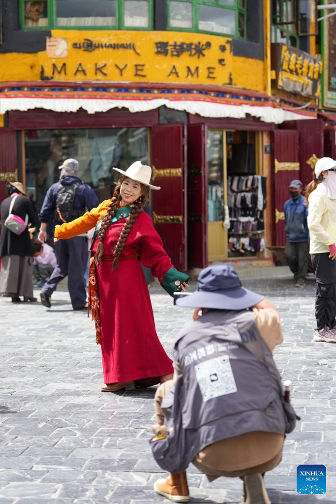 Tourists in Xizang adorn themselves in traditional Tibetan costumes