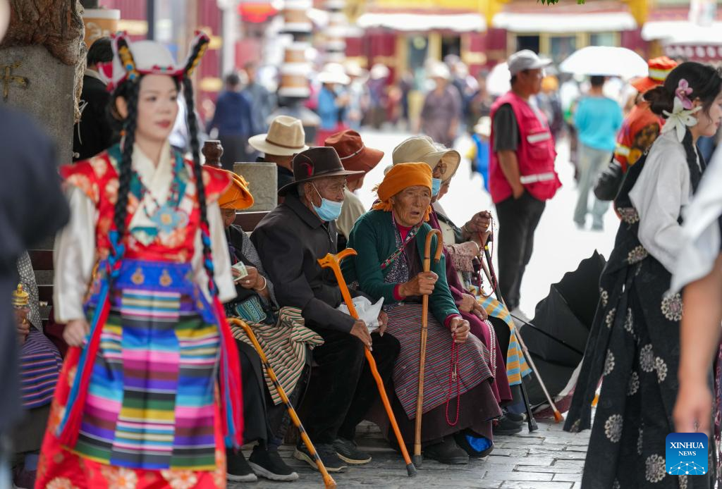 Tourists in Xizang adorn themselves in traditional Tibetan costumes