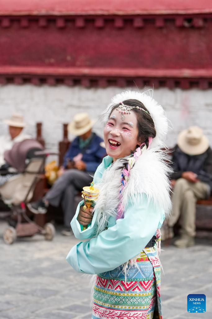 Tourists in Xizang adorn themselves in traditional Tibetan costumes
