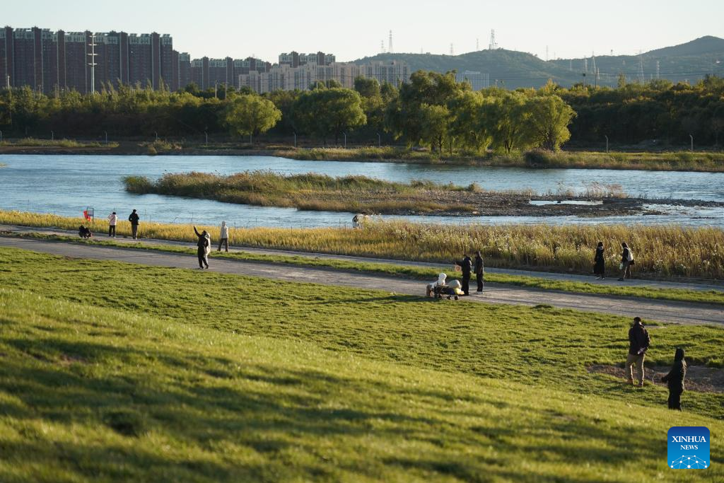 People enjoy leisure time by Yongding River in Beijing