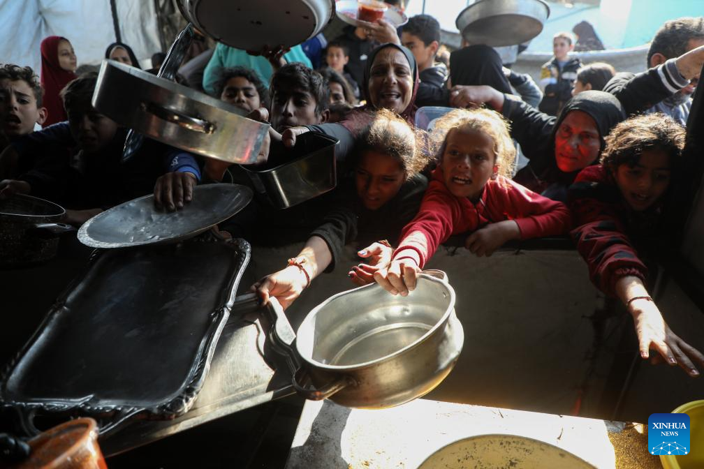 Displaced Palestinians receive free food in northern Gaza Strip