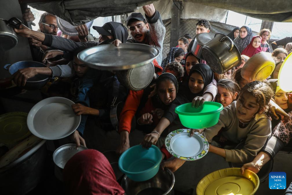 Displaced Palestinians receive free food in northern Gaza Strip