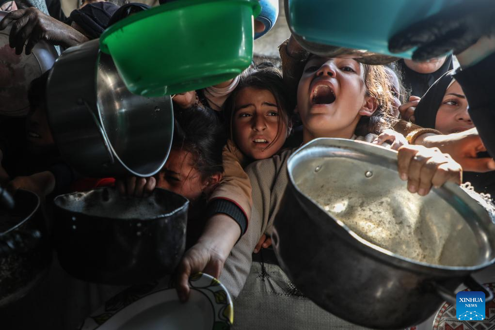 Displaced Palestinians receive free food in northern Gaza Strip